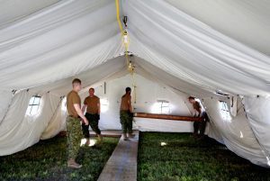 Members of the Canadian Armed Forces carry floorboards into the tents they erected to house asylum seekers at the Canada-United States border in Lacolle, Quebec