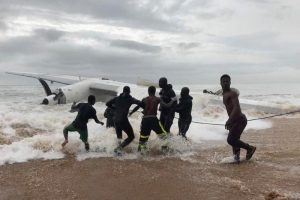 People pull the wreckage of a propeller-engine cargo plane after it crashed in the sea near the international airport in Ivory Coast’s main city, Abidjan