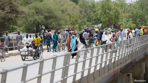 People cross the bridge linking Cameroon to Nigeria at Gamboru/Ngala in Borno, Nigeria