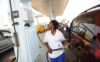 A fuel attendant fills a tank at a gas
